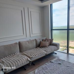 un divano in soggiorno con una grande finestra di French village two a Duhok