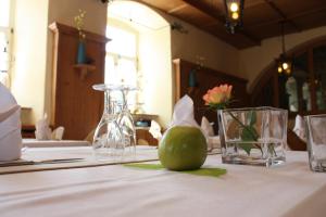 a table with a white table cloth with a green pear on it at Hotel Jean-Paul in Schwarzenbach an der Saale