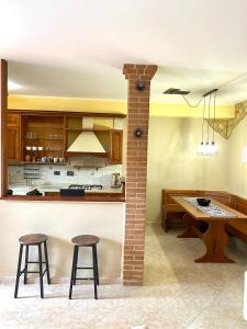 a kitchen with two bar stools and a table at Domus Ciampino 4 bedrooms apartment in Ciampino