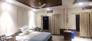Un dormitorio con una cama y un ventilador de techo. en Oh lovely Lake, en Udaipur