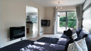 a living room with a couch and a tv at Superb 4BD Stay in Wyton and Houghton Village in Wyton