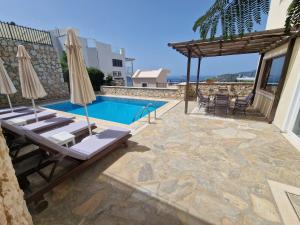 カシュにあるVilla Gwendolineの建物の隣にプール(椅子、パラソル付)