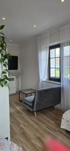 a living room with a couch and a window at Gościniec Husarski in Sandomierz