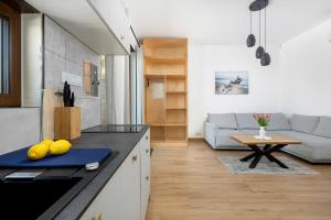 eine Küche und ein Wohnzimmer mit einer Couch und einem Tisch in der Unterkunft Apartamenty Piaskowa 11 in Gąski