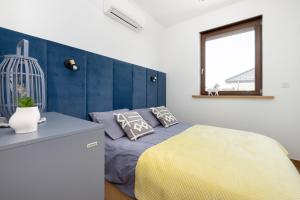 ein Schlafzimmer mit einem Bett mit einer gelben Decke und einem Fenster in der Unterkunft Apartamenty Piaskowa 11 in Gąski