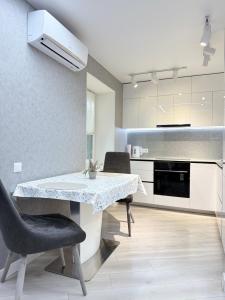a kitchen with a dining room table and chairs at Modern Gagarina Avenue in Dnipro