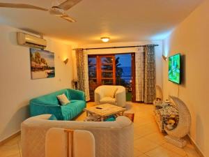 a living room with a couch and chairs and a table at Shanzu Oceanline Apartments La Mera in Mombasa