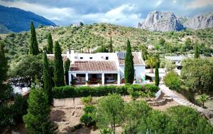 an aerial view of a white house with trees and mountains at Romantisches Apartment, Finca nahe Malaga in Ríogordo