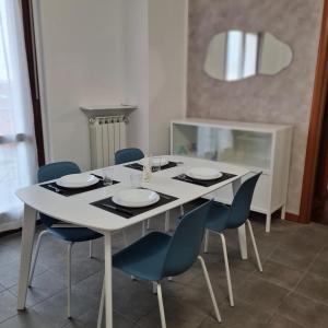a white dining room table with blue chairs and a white at Casa Gavazzeni Il Sogno in Bergamo