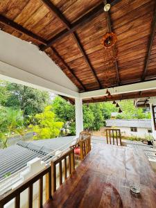 an outdoor dining room with a wooden ceiling at Sigiriya Sweet Home Guest House in Inamaluwa