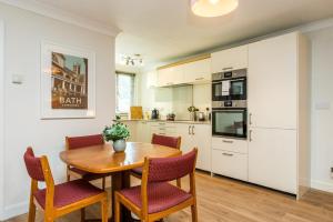 a kitchen and dining room with a wooden table and chairs at NEW Cosy 1BD Flat close to Kew Gardens Richmond in London +9 photos