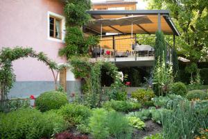 einen Garten vor einem Haus mit einer Terrasse in der Unterkunft Der Unterwirt Guesthouse and Restaurant in Klausen