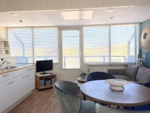 eine Küche und ein Wohnzimmer mit einem Tisch und einer Couch in der Unterkunft Fijne vakantiehuizen 50 mtr van het strand in Egmond aan Zee