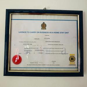 a certificate in a framed picture of a home stay unit at Sigiriya Sweet Home Guest House in Inamaluwa