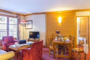 een woonkamer met een tafel met daarop een laptop bij Résidence Les Sources de Marie - ARCS 1950 in Bourg-Saint-Maurice