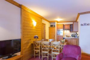 een keuken en eetkamer met een tafel en stoelen bij Résidence Les Sources de Marie - ARCS 1950 in Bourg-Saint-Maurice