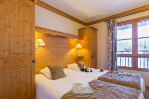 een slaapkamer met 2 bedden en een hond op het bed bij Résidence Les Sources de Marie - ARCS 1950 in Bourg-Saint-Maurice +11 foto's