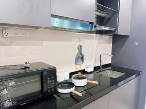 a kitchen with a microwave and a stove top oven at Encorp Marina Puteri Harbour 2Bed Bathtub in Iskandar Puteri