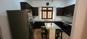 a kitchen with a refrigerator and a table in it at Spacious and Serene Family Home in Colombo in Colombo
