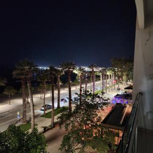 - une vue sur une rue bordée de palmiers la nuit dans l'établissement JRL Residence, à Vlorë