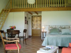 a bedroom with a bed and a table and chairs at Gites le Fabras, espace de verdure, piscine collective et jeux in La Bâtie-Rolland +82 photos