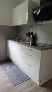 a kitchen with white cabinets and a sink at FeWo Marjenza in Wermelskirchen