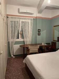 une chambre avec un lit, une table et une fenêtre dans l'établissement A1 Kalamata Rent, à Kalamata