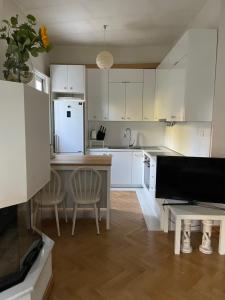 une cuisine avec des armoires blanches et une table et des chaises dans l'établissement A1 Kalamata Rent, à Kalamata