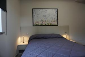 Un dormitorio con una cama y un cuadro en la pared. en Le vie del mare , Ribolla, en Ribolla