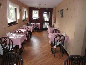 a dining room with tables and chairs with pink tablecloths at Albert Villa Guest House in Perth