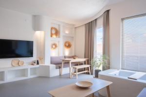 a white living room with a tv and a table at L'olive homes in Marmaris