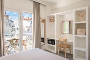 a bedroom with a bed and a desk and a balcony at L'olive homes in Marmaris