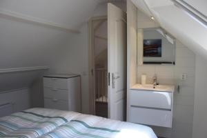 une petite chambre avec un lit et un lavabo dans l'établissement Heerlijke vakantiehuisjes in Egmond, à Egmond aan Zee 37 autres photos
