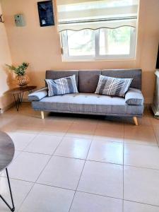 a living room with a couch and a window at Menƴ's Azure Escape in Dhíkella