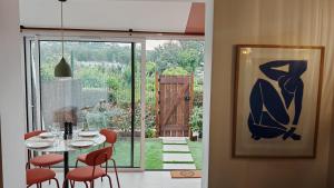 a dining room with a table and chairs and a sliding glass door at Jolie Maisonnette vençoise in Vence