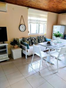 a living room with a table and a couch at Menƴ's Azure Escape in Dhíkella +28 photos