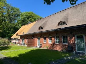 a brick building with a grass yard in front of it at Ferienwohnungen Unter den Eichen in Stade
