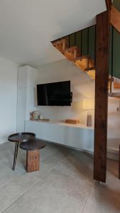 un soggiorno con un tavolo e una TV a parete di Jolie Maisonnette vençoise a Vence Altre 25 foto