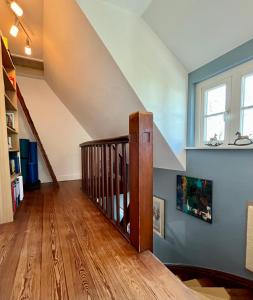 a living room with a staircase and a window at Kleine Landhaus-Perle am Schlosspark in Eutin
