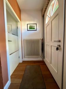 a hallway with a white door and a window at Kleine Landhaus-Perle am Schlosspark in Eutin