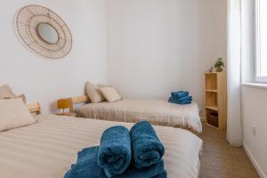 a bedroom with two beds with blue towels on them at Pause méditerranéenne en plein centre in Béziers