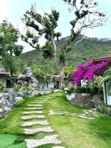a garden with a stone path next to a house at Tran Chau Garden Home in Cat Ba