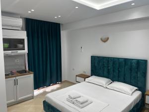 a bedroom with a large bed with a green headboard at Guesthouse Mance in Ksamil +71 photos