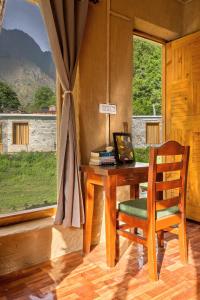a wooden desk with a chair and a window at Himalayan Willow in Gushaini