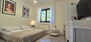 a white bedroom with a bed and a window at Gościniec Husarski in Sandomierz