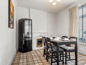 a dining room with a table and a black refrigerator at Workington Haven - 3 Bed Home in Workington