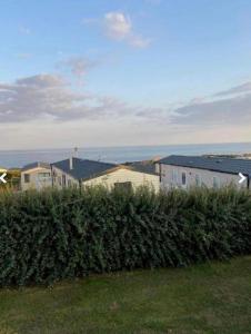 a row of houses with bushes in front of them at Platinum 3 Bedroom Caravan, Wifi, Parking, Seaview, in Budleigh Salterton