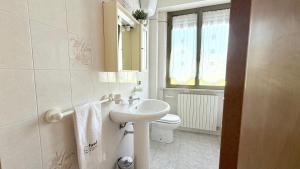 a white bathroom with a sink and a toilet at PP06 - Porto Potenza, trilocale con aria condizionata vicino al mare in Porto Potenza Picena +17 photos