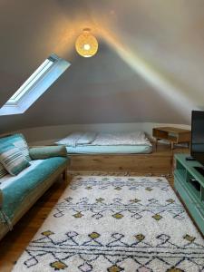 a attic room with a bed and a couch at The Millers Cottage in Cambridge