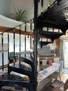 a black spiral staircase in a room with a table at The Millers Cottage in Cambridge